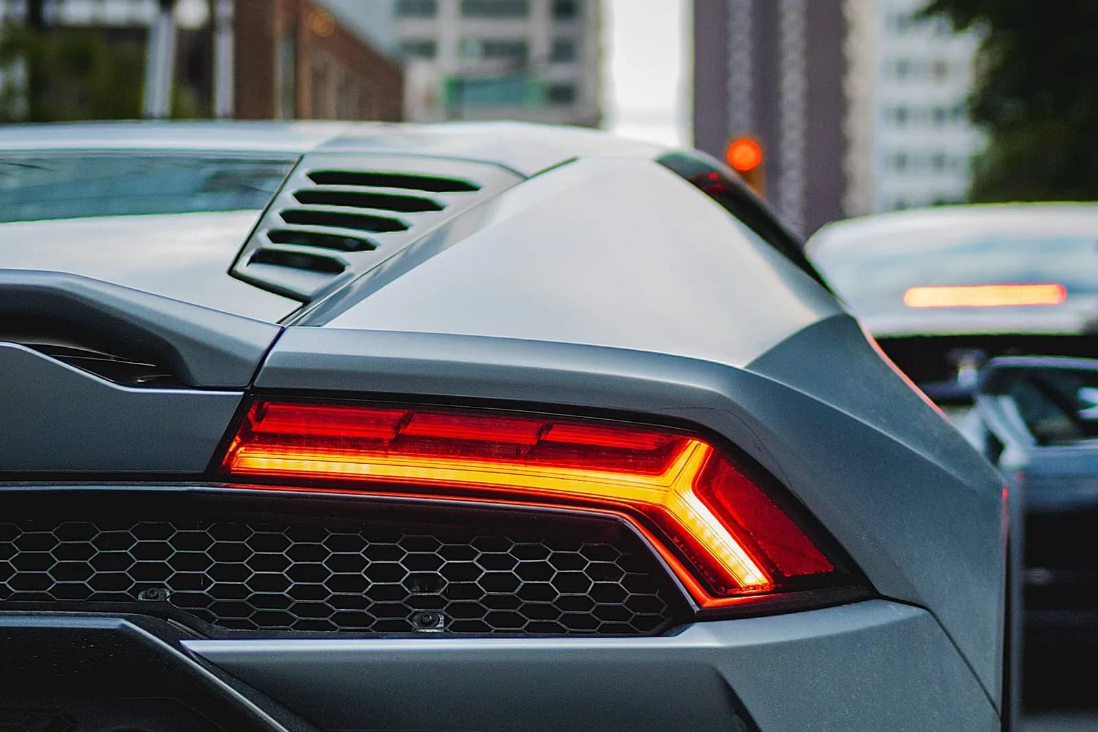 Close crop on the rear of the Huracán, the tail light lit above the vents.